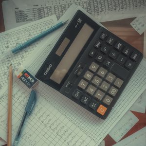 a calculator sitting on top of a pile of papers